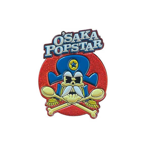 Cartoon skull logo with blue hat and sunglasses for Osaka Popstar Crunchy Crossbones Enamel